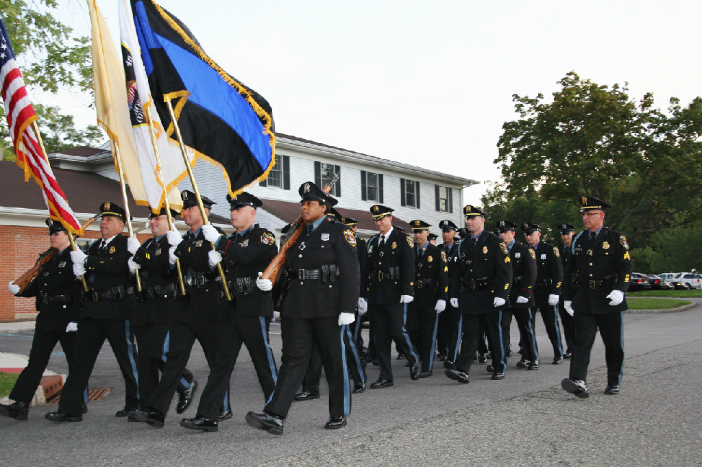 Honor Guard marching with flags in front of a building. 